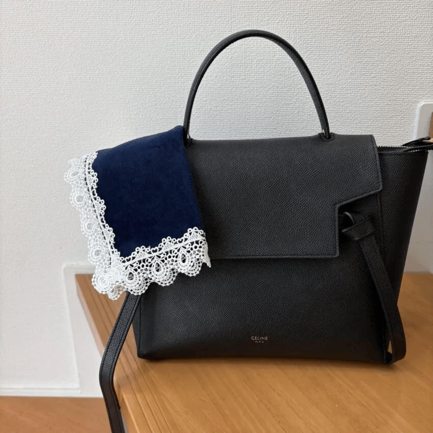 近沢レース店「タオルハンカチ/ミニヨン(ネイビー)」黒バッグにのせたところ