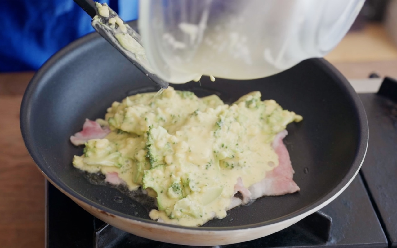 熱したフライパンに、サラダ油大さじ1/2を入れて①の豚肉を広げ、その上に③を流し入れる。生地を厚さ1.5cmほどになるように広げ