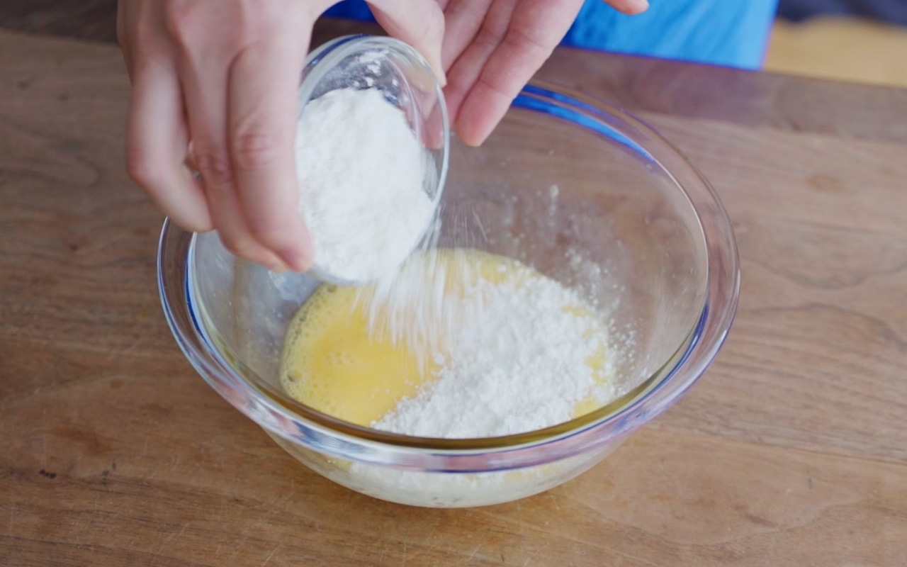 ボウルに卵をいれて溶きほぐし、水とお好み焼き粉を加えてダマがなくなるまで混ぜる