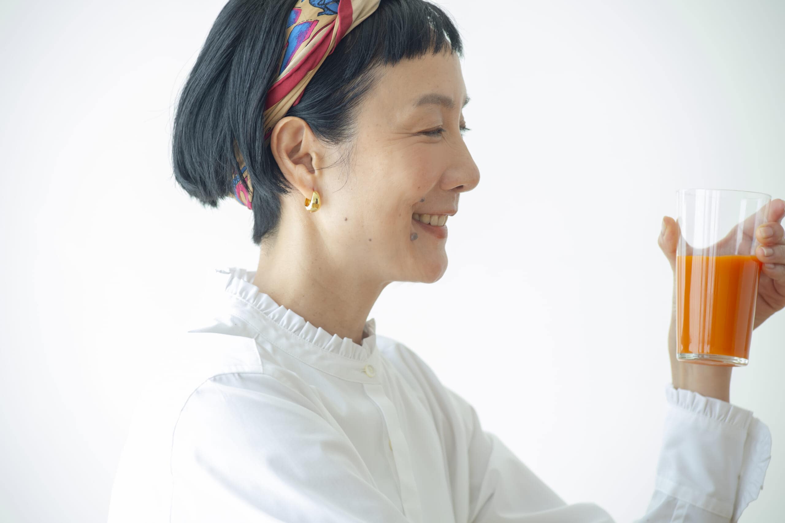 グラスに入ったカゴメにんじんジュース高β-カロテンを見つめるはなさん