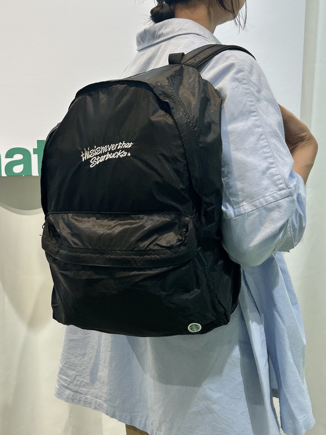 スターバックス thisisneverthat　パッカブル バックパックを背負った女性