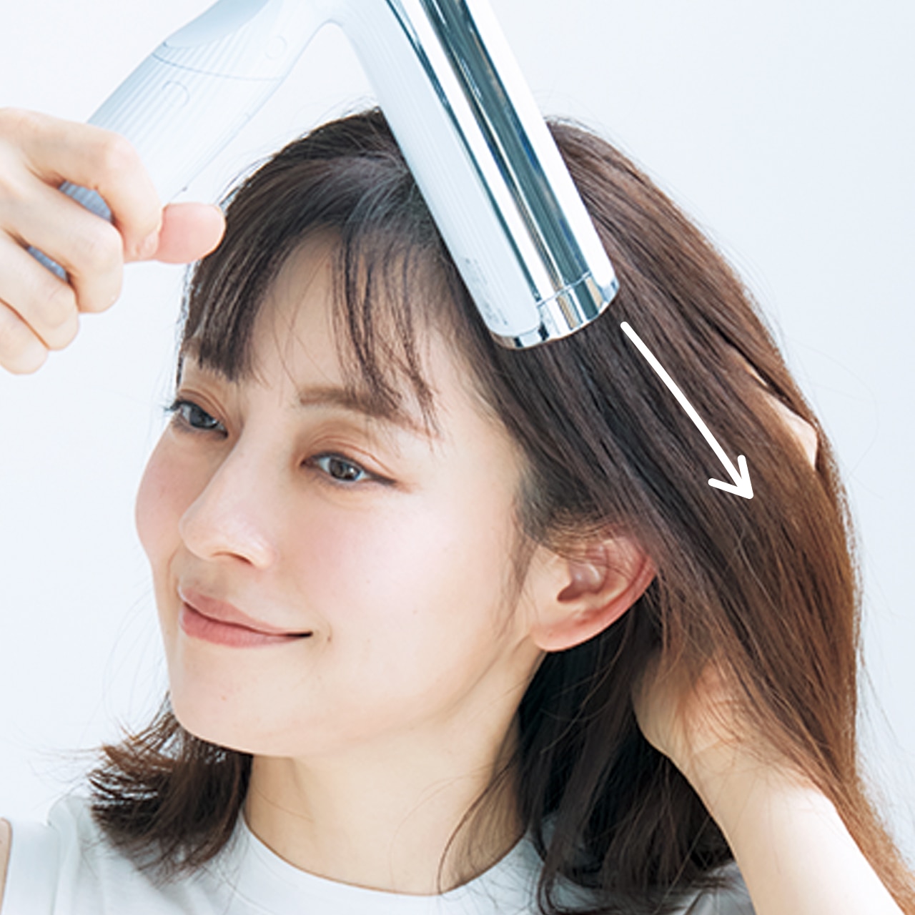 毛を持ち上げながら根元からオイルを塗布し、下方向にテンションをかけながら乾かして