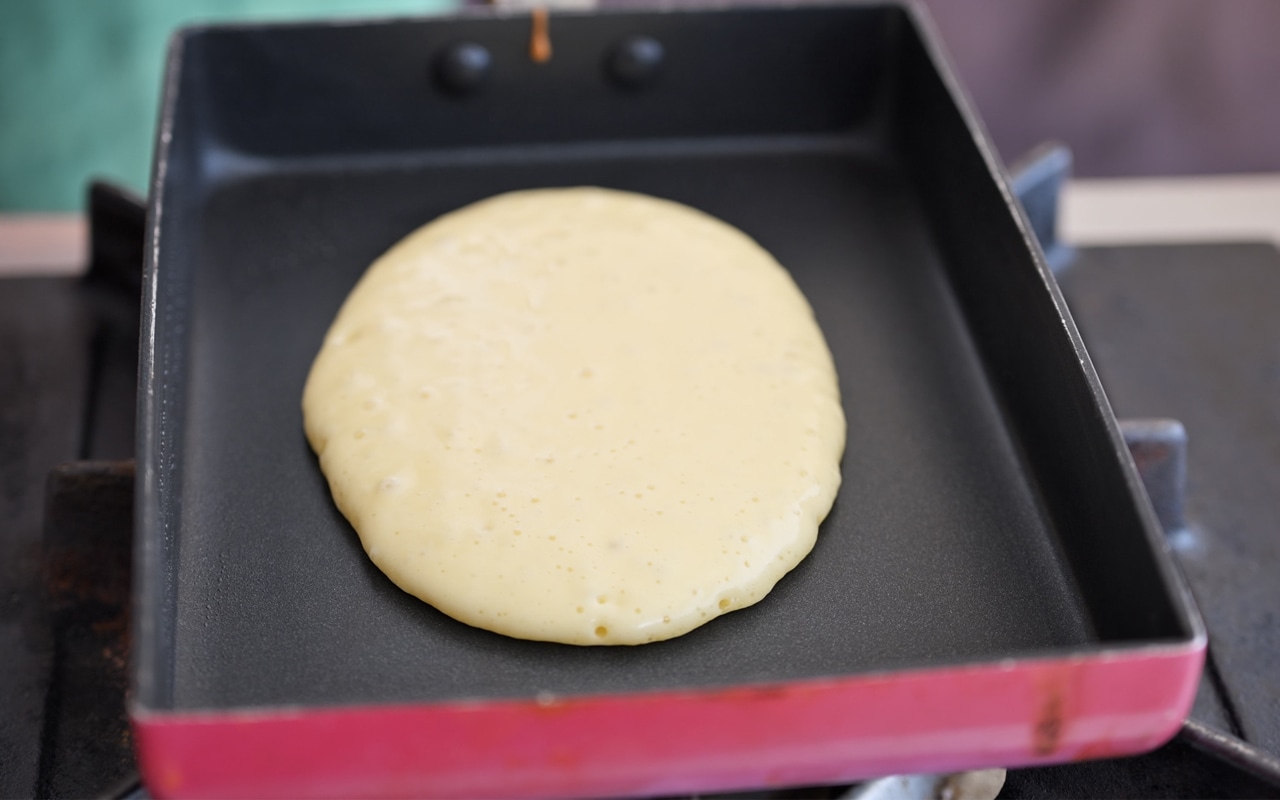 小さめのお玉１杯分くらいの生地を楕円状に薄く流し入れる。