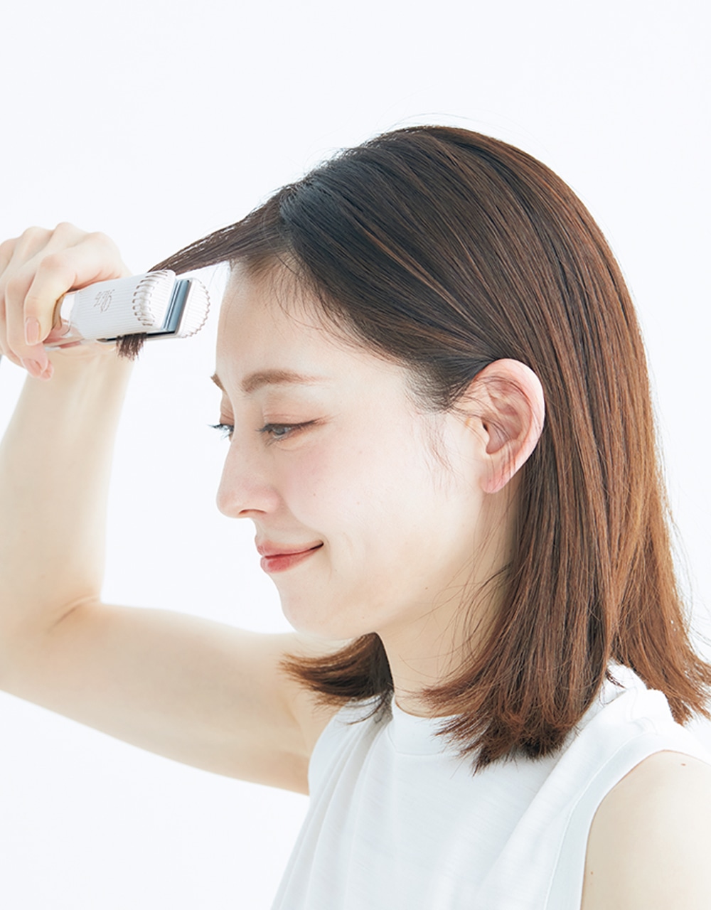 はヘアアイロンで前髪が額につかないように、大きく弧を描くようすべらせて