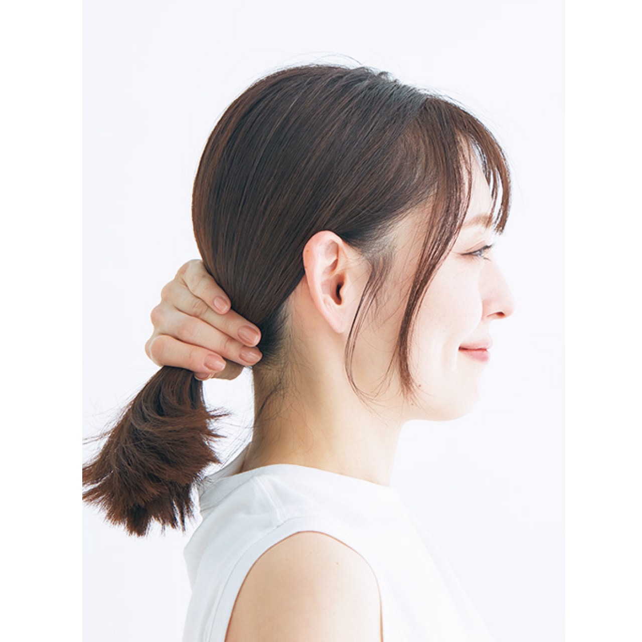 2.サイドの毛束を2本下ろして1本結び