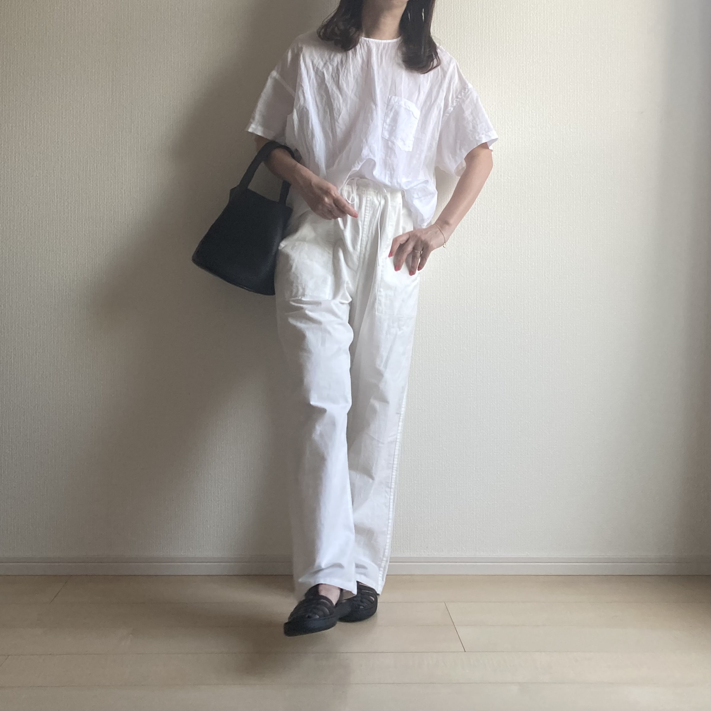 40代の涼しいブラウスと白パンツの爽やか涼しいコーデ。黒のグルカサンダルとバッグを合わせたモノトーンコーデ。