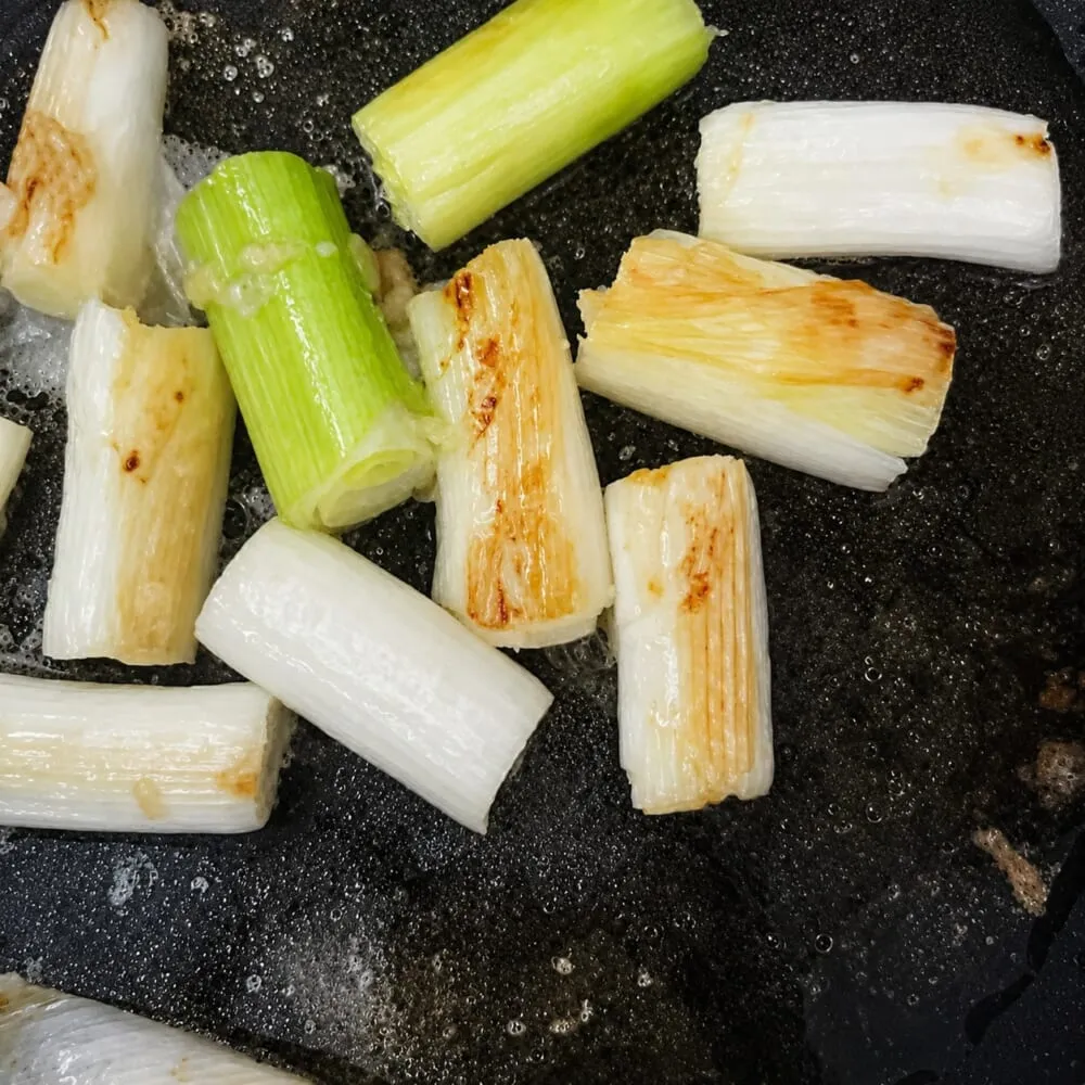 「鶏むね肉のアクアパッツァ風」レシピ　ネギを炒める