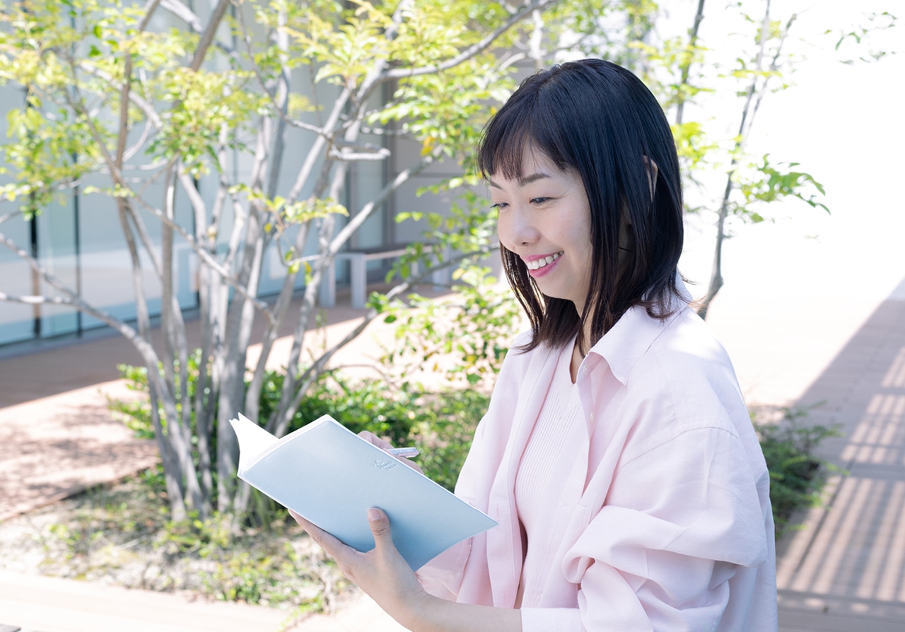 手帳を見ながら今日1日を想像する吉武麻子さん