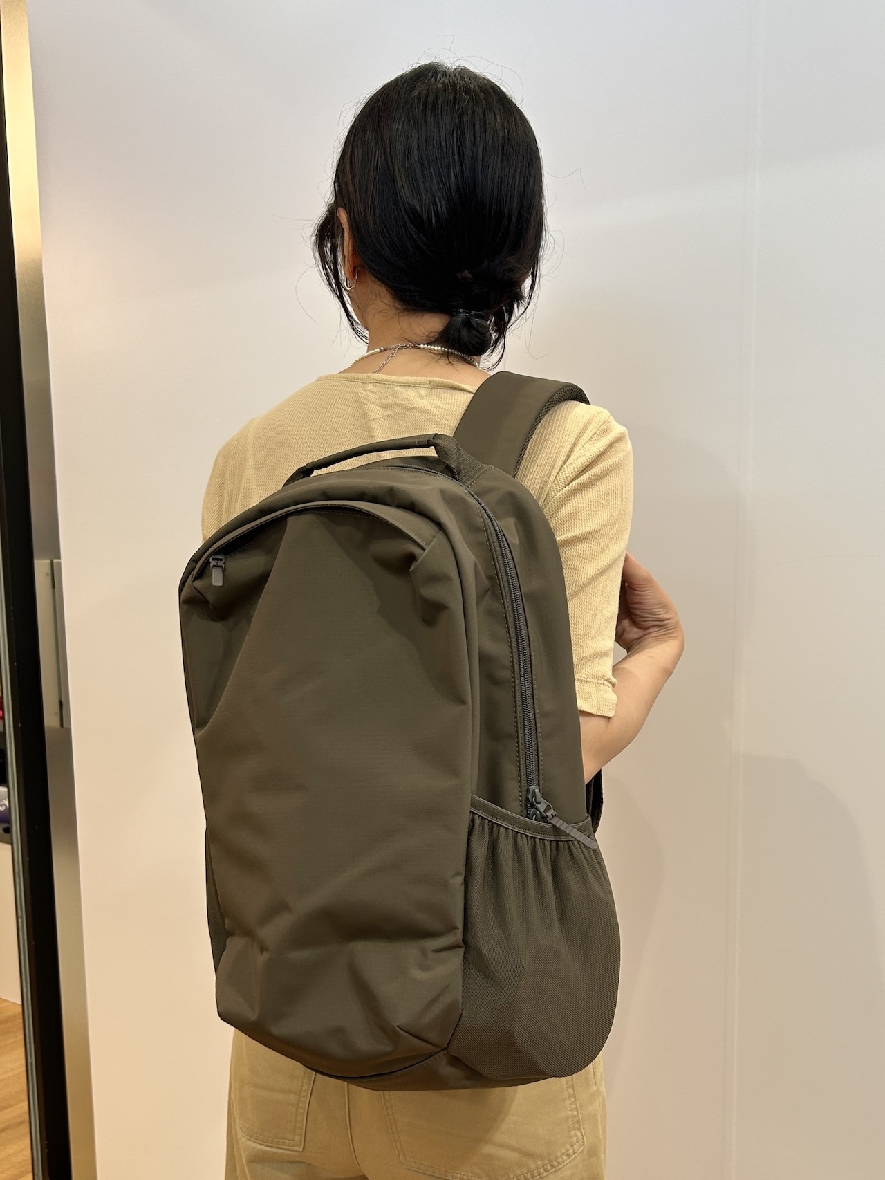 ユニクロ「ユーティリティバックパック」オリーブを背負った女性