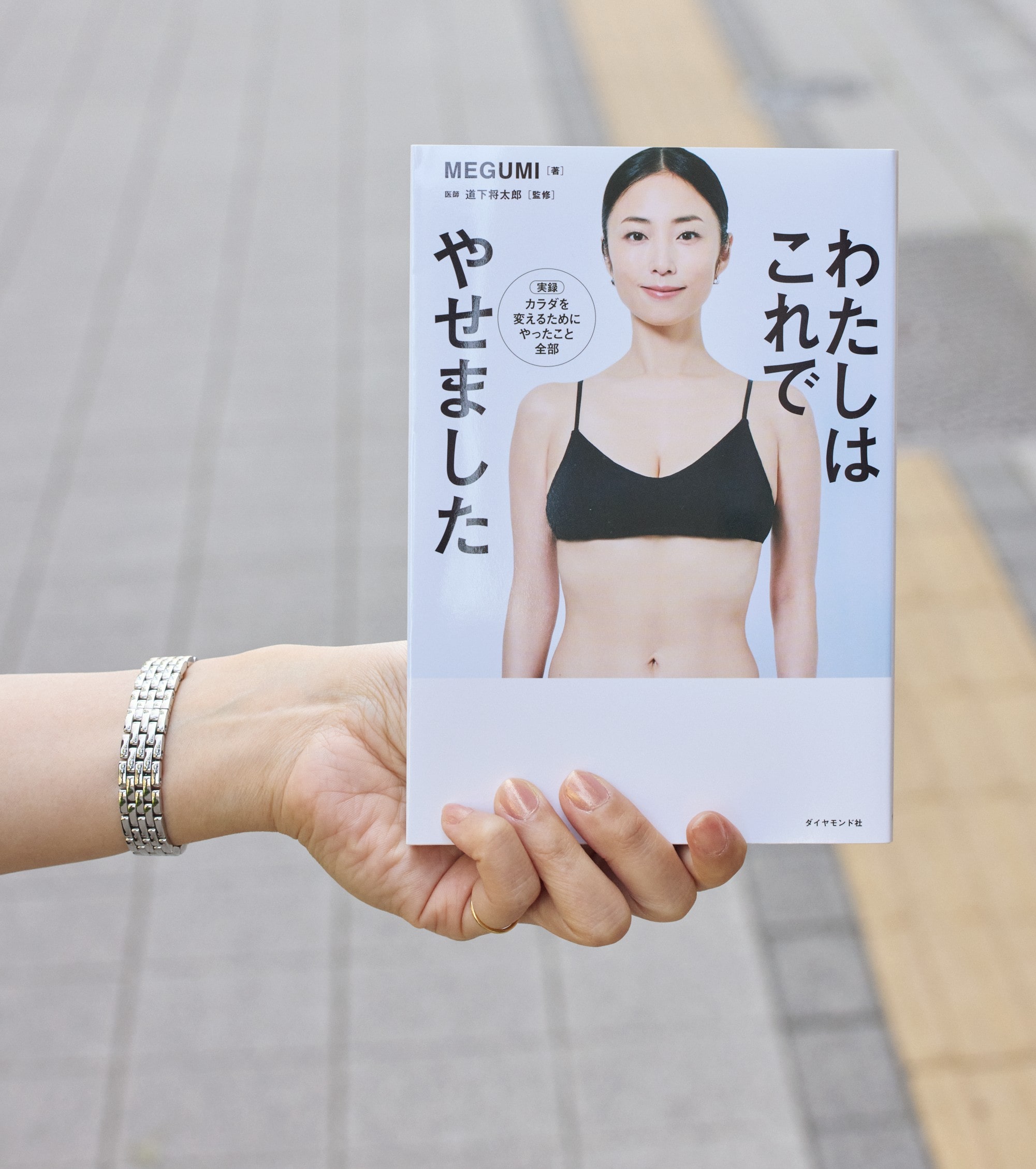 MEGUMIさんの著書『わたしはこれでやせました』を手に持った写真