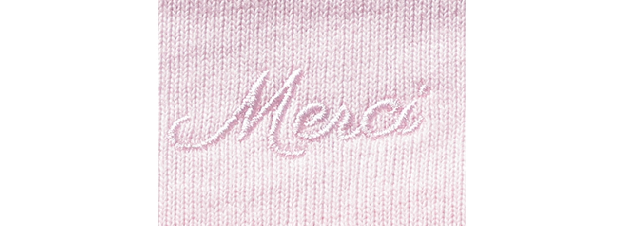 クルーネックの首元後ろには、身頃と同色の糸で「Merci」の刺しゅうをプラスし、さりげないポイントに!