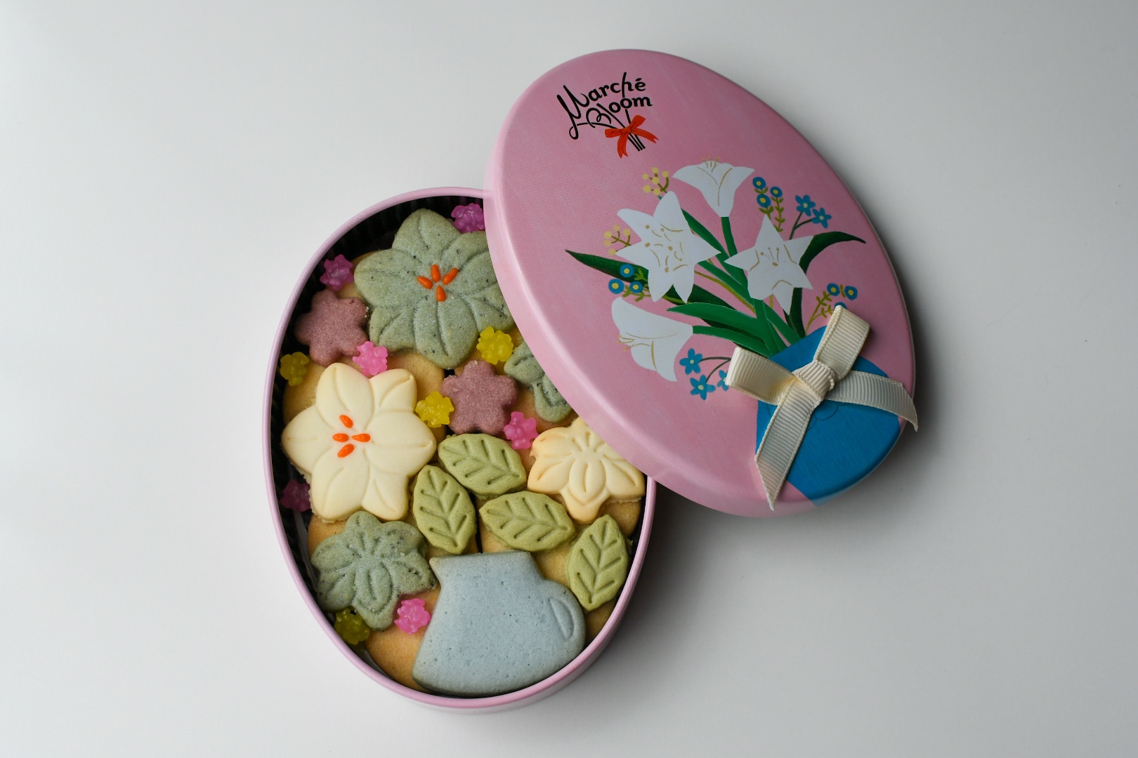 白百合のブーケを描いたMarché Bloom「リリーベース」と、花や葉をかたどった色とりどりのクッキー