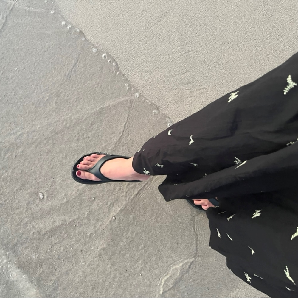 LEE100人隊のサンダルと黒いスカートの足元