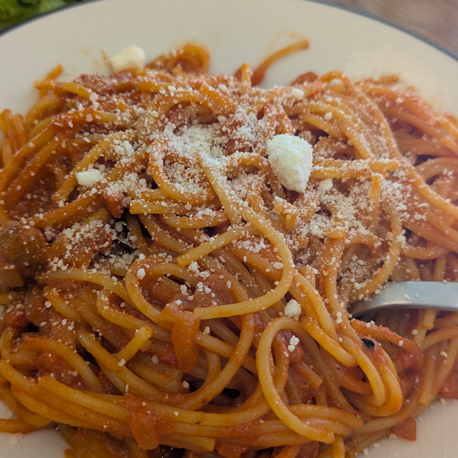 粉チーズをかけたコウケンテツさんレシピのトマトソースパスタ