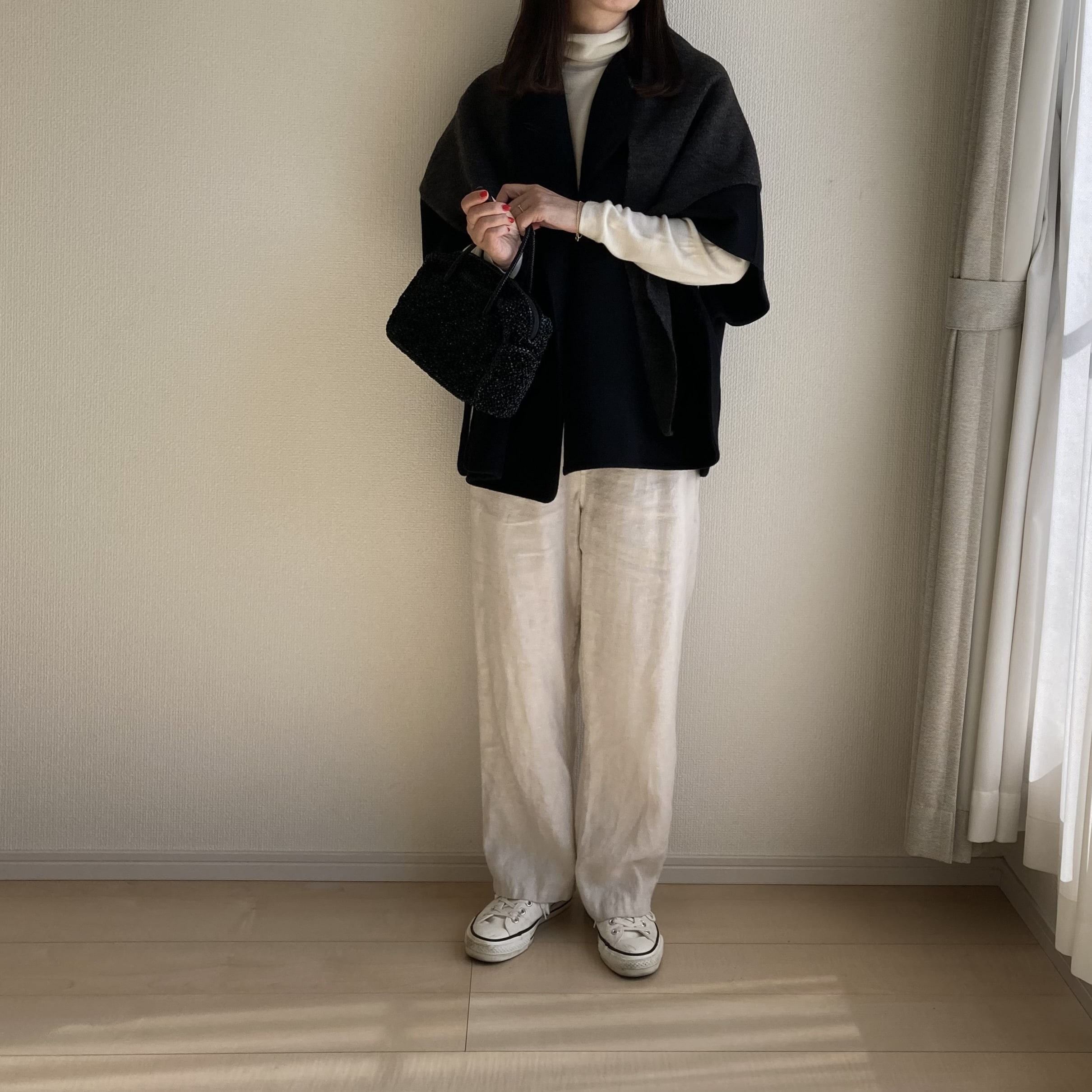 50代女性がユニクロ「スフレヤーントライアングルスカーフのダークグレー」をコートの上から羽織ったコーデ。