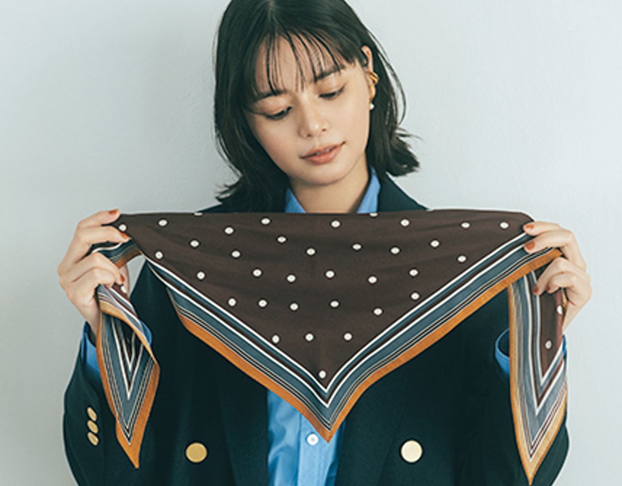 三角が中心にくるようにスカーフを正面に持ち、首の後ろでクロスする。 岸本セシルさん